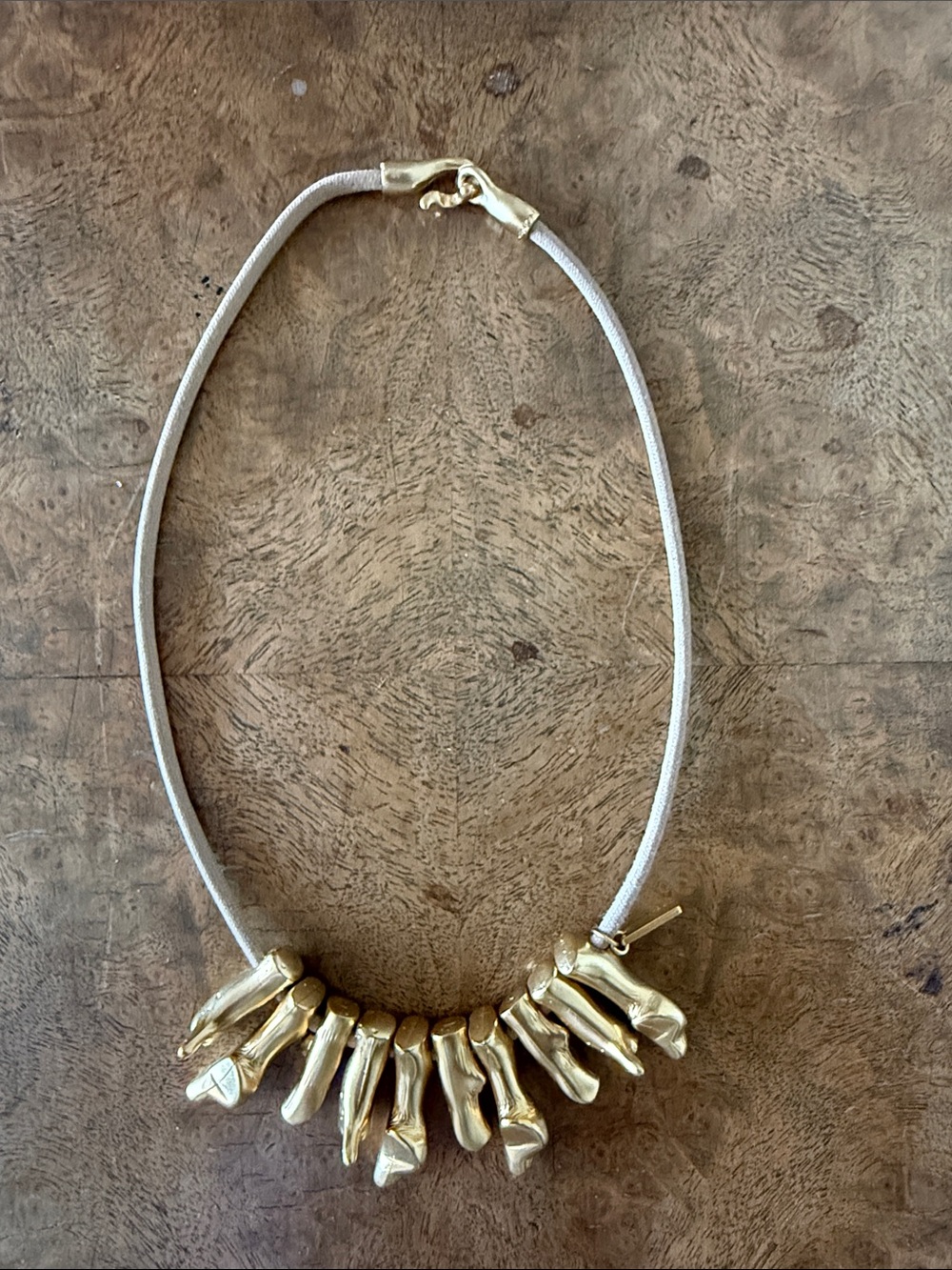 Gold Sculptural Pendant Necklace on Cream Cord by